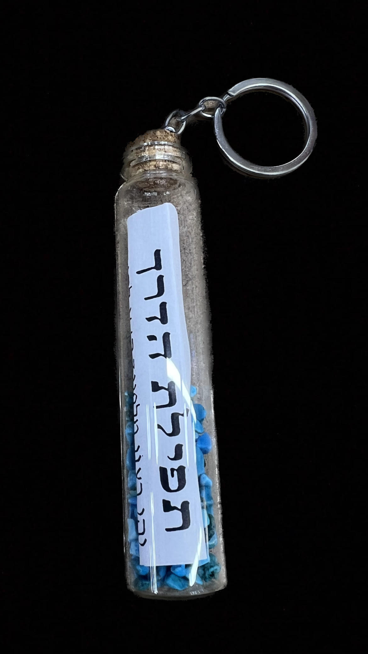 מחזיק מפתחות בצורת בקבוק בגודל 10.5x2 ס”מ.
הבקבוק מכיל אבנים קטנות בצבע כחול עם תפילת הדרך.
